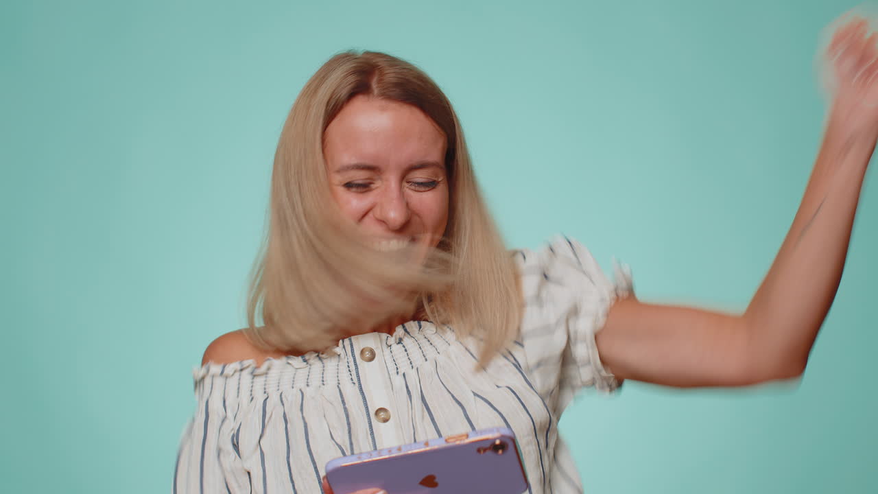 обеспокоенная забавная зависимая женщина с энтузиазмом играет в гоночные видеоигры на мобильном телефоне