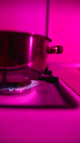 pot on a gas stove with pink light