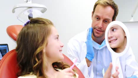 Dentist-teaching-girl-to-a-brush-teeth