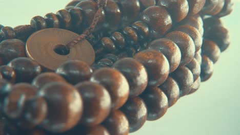 macro rotating shot of a wooden round beads necklace with coin medallion