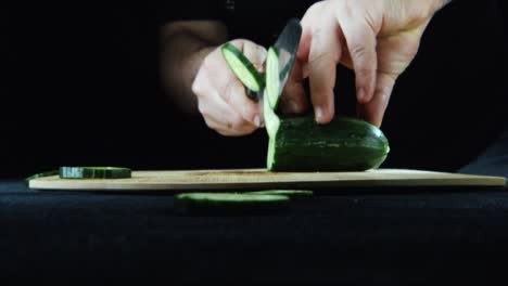 slicing cucumbers on a wooden cutting board