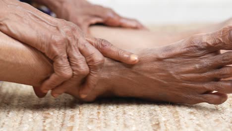 Close-up-on-senior-women-feet-and-hand-massage-on-injury-spot