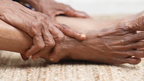close up on senior women feet and hand massage on injury spot