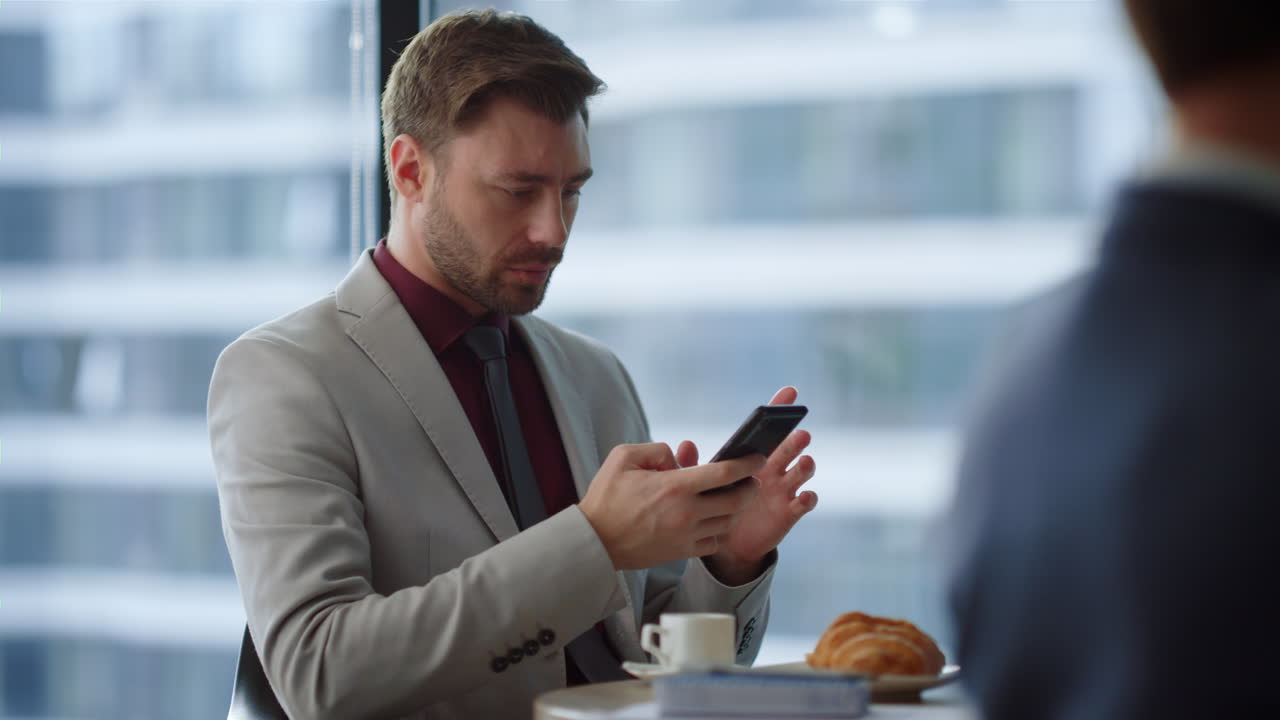Focused business man typing on mobile phone