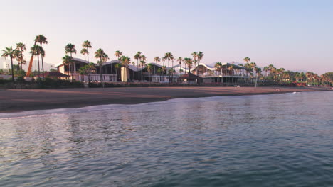 Panoramic-view-over-the-sea-of-Playa-del-Padrón,-Marbella,-Spain,-during-sunset-with-a-clear-sky-and-calm-ocean-waves,-slowly-panning-from-left-to-right