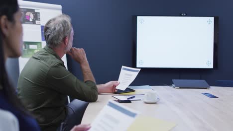 diversos colegas de negocios sentados mirando la pantalla en la reunión de la oficina