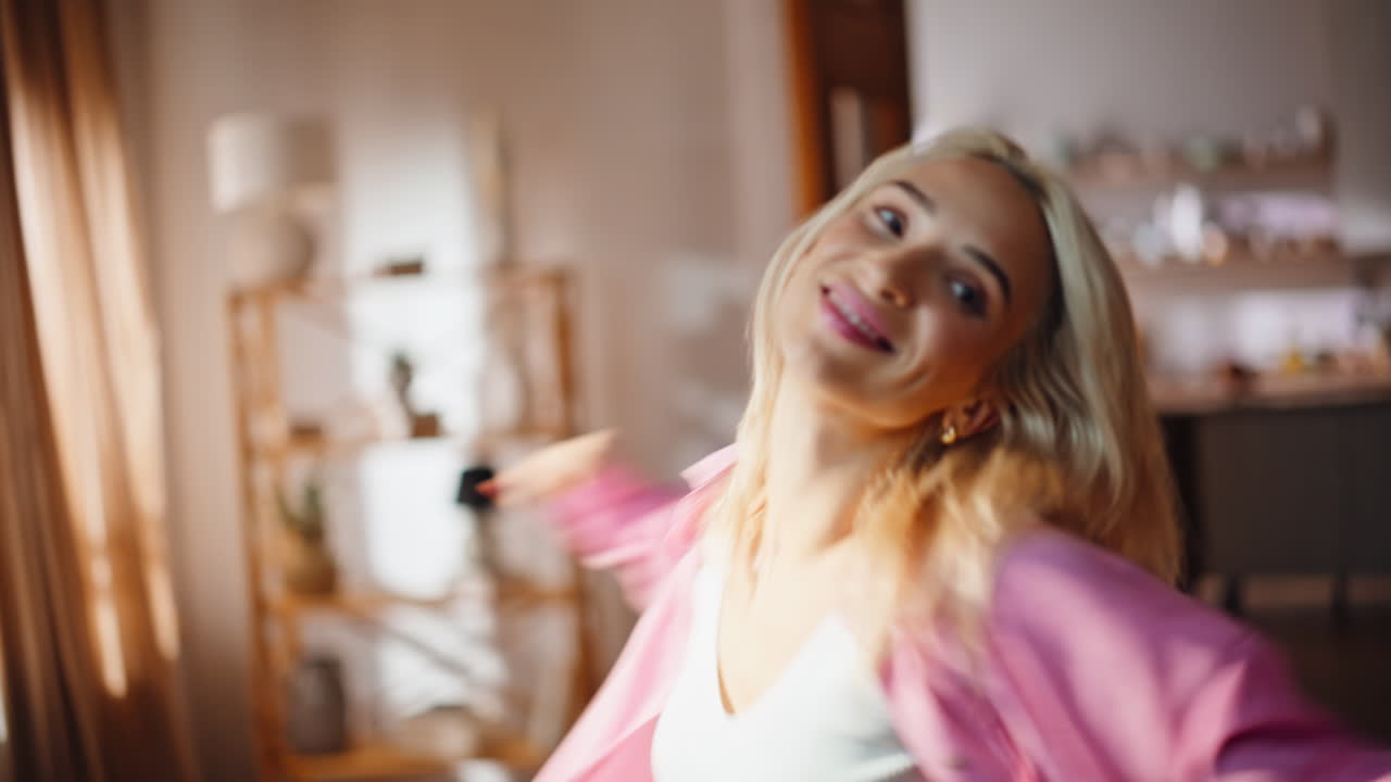 Ritratto di una donna energica che balla in un appartamento soleggiato. Ragazza felice e sorridente che muove il corpo