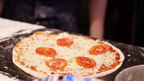 preparando pizza con rebanadas de queso y tomate
