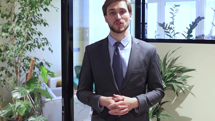 Uomo d'affari fiducioso che sorride e parla in un ufficio moderno