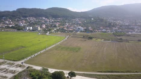 Aerial-grass-field-outside-Lisbon,-Portugal-close-to-main-road