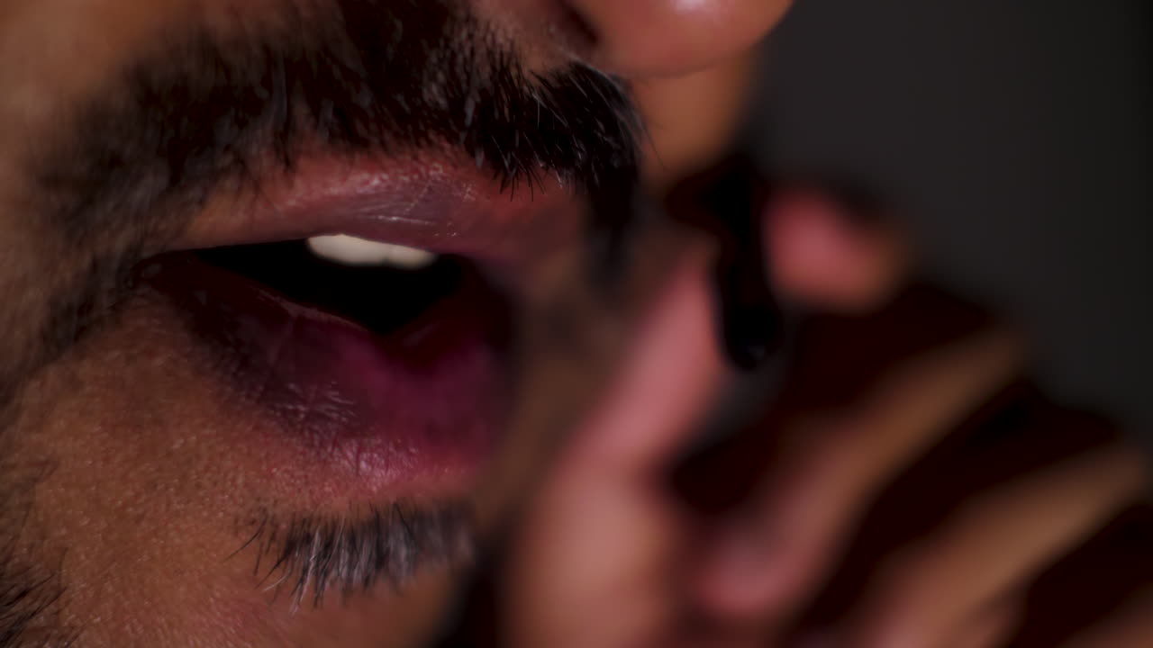 fotografía macro de la boca de un hombre asiático involucrado en una conversación, destacando la representación de expresiones faciales, gestos y comunicación