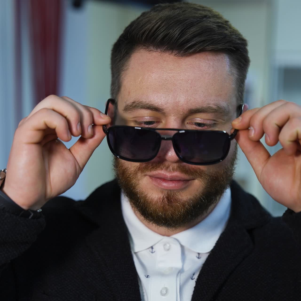 Handsome man chooses fashion sunglasses in optics. Wide assortment of modern eyewear in shop