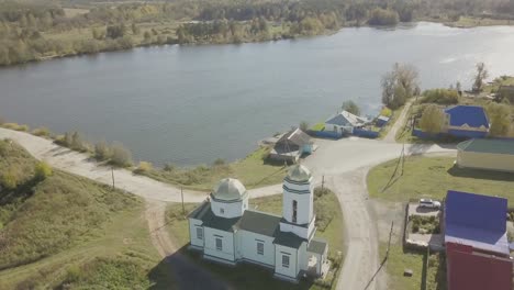 aerial view of a village with a church by a lake