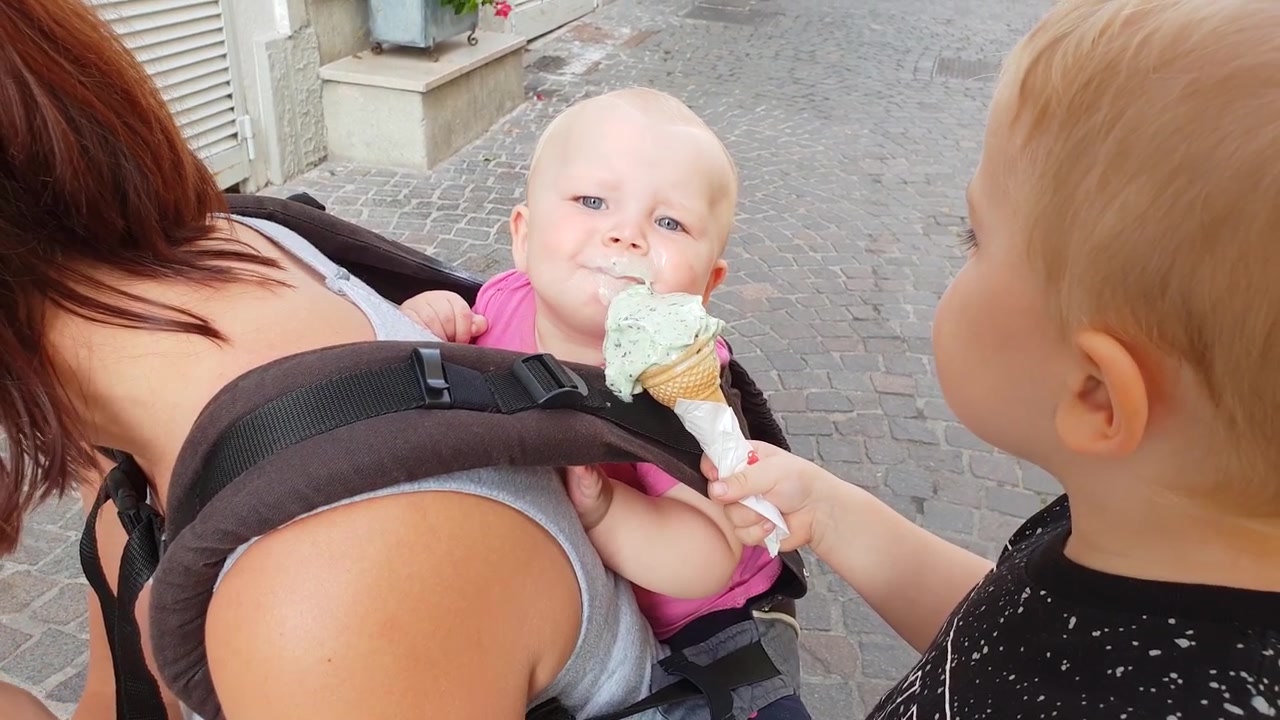 Niño dando helado a una niña pequeña en el Lago de Garda, en el norte de Italia, en un soleado día de septiembre