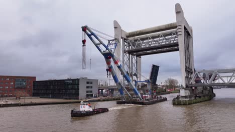 beneath the bridge, an industrial crane floats gracefully on the water