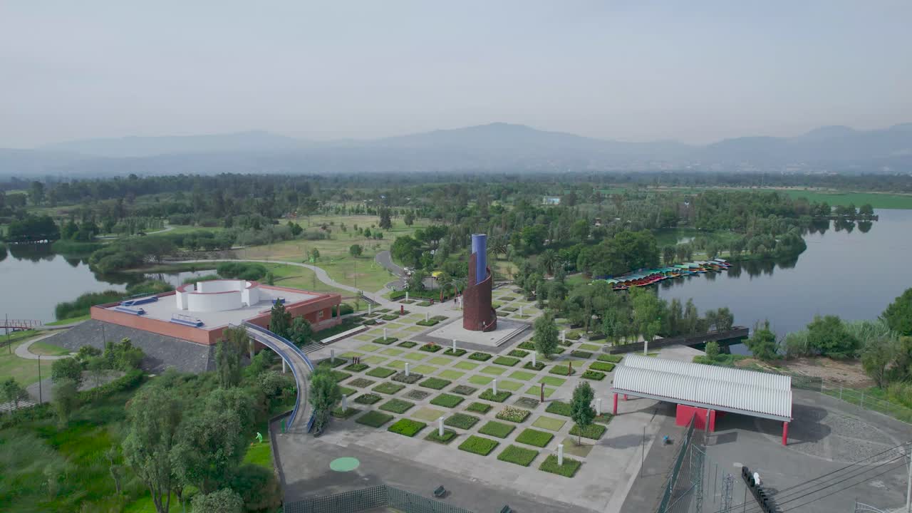 Orbital footage above a lake with view of lake, a highway and a natural area in Xochimilco, Mexico City (part four)