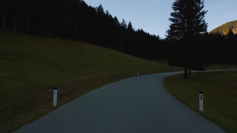 POV-point-of-view-car-drive-in-Alps-valley-mountain-peaks-in-Austria-Tyrol-with-romantic-and-scenic-roads-in-natural-sunset-landscape