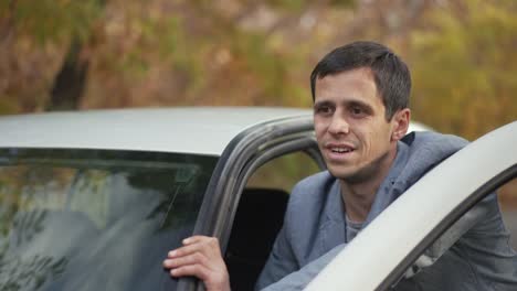 man pushing a broken car