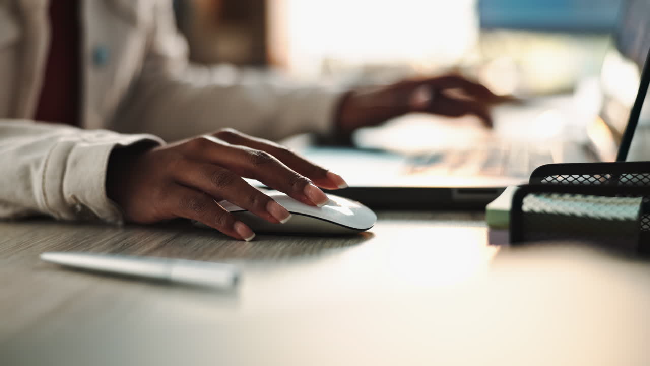 A person working on a computer using a mouse
