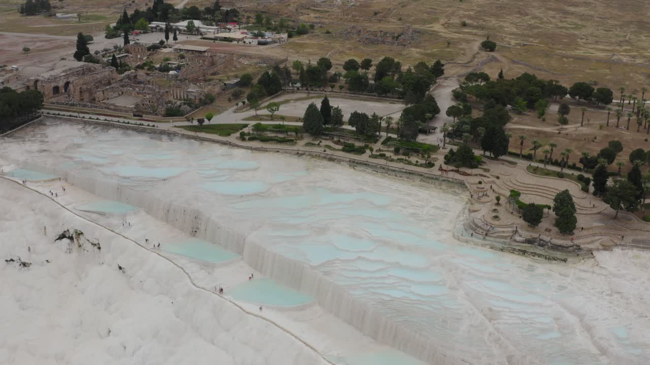 drone volando sobre las terrazas de travertino de la piscina termal natural de pammukale y la histórica hierápolis romana en el fondo de turquía