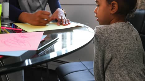 Young-mother-helping-her-daughter-with-homework-on-table-4k