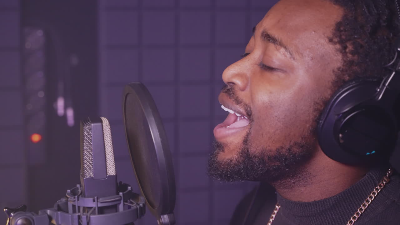Man Singing Into Microphone in Recording Studio