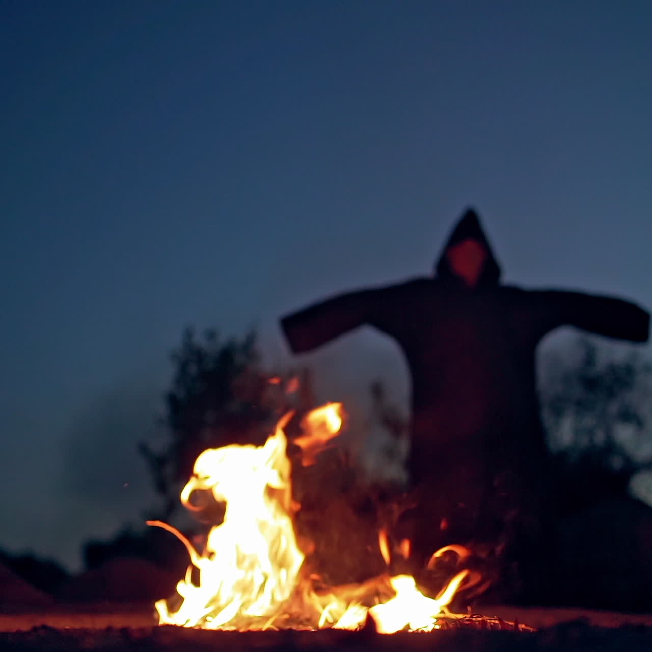 An old witch conjures on Halloween Day of the Dead. Burning fire. Bonfire.