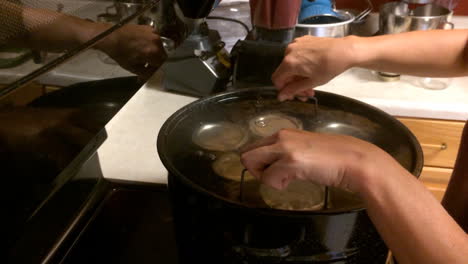 woman making canned applesauce in kitchen