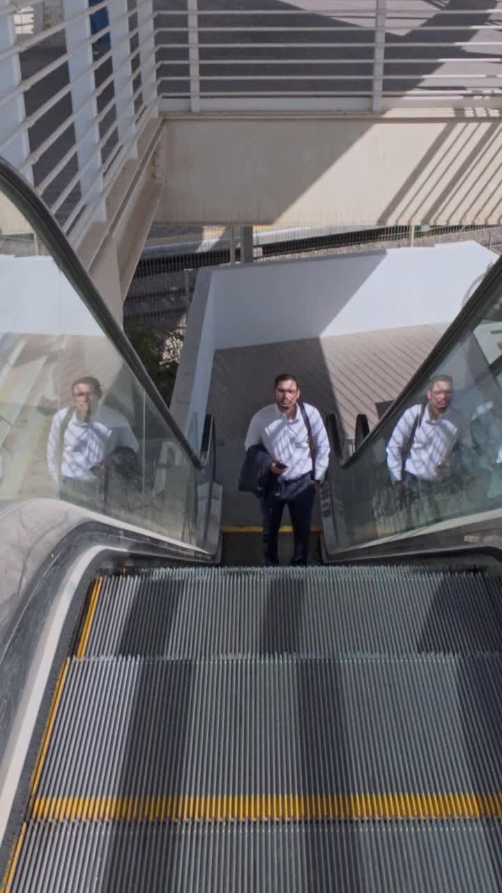 Vista superior de um homem chegando ao fim de uma escada rolante