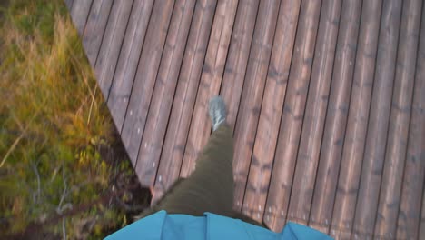 pov shot of a person walking on a boardwalk over a marsh in iceland