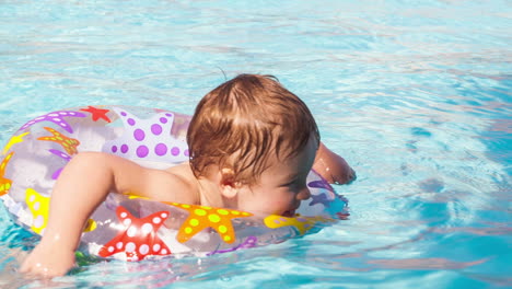 Kid-learns-to-swim-using-a-plastic-water-ring