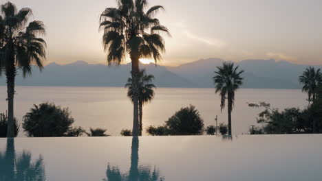 Escena-Del-Atardecer-Del-Resort-Con-Piscina-Mar-Y-Montaña