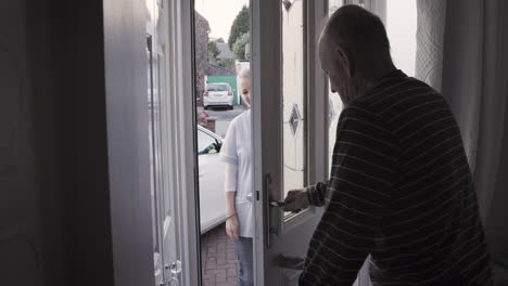 elderly man opening door with nurse