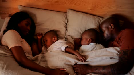 young loving couple with little children sleeping together in bed