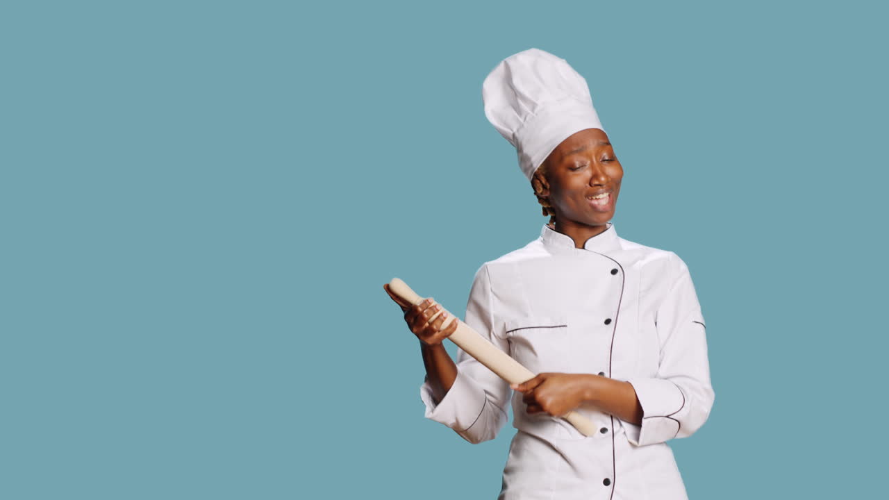 Allegro e simpatico chef che gioca con un mattarello e canta