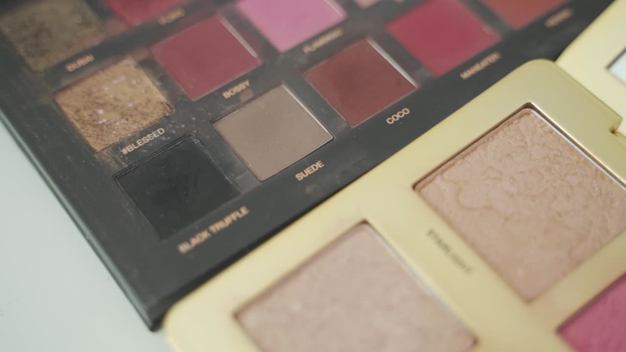 다양한 모양과 스킨케어 화장품을 위한 다양한 색상의 컨투어링, 컨실러 및 메이크업 팔레트 - 느린 매크로 샷을 닫습니다.