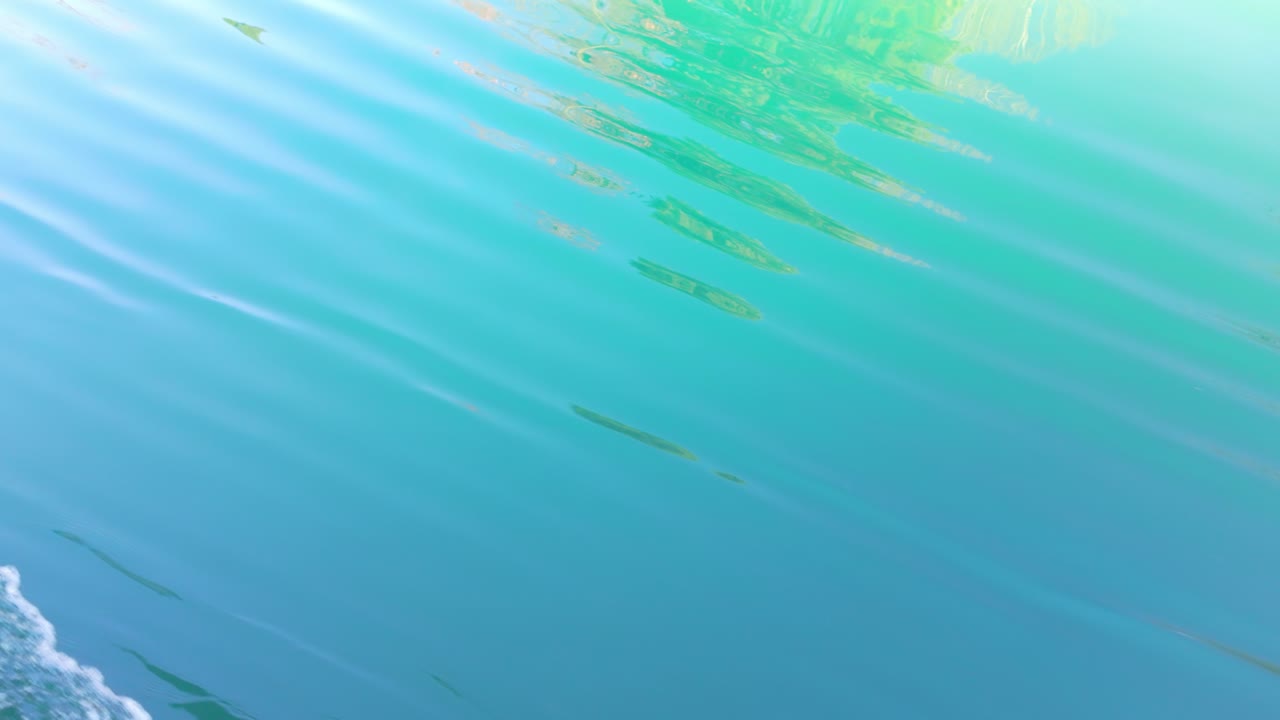 Lake Thun with clear turquoise rippled waters near Spiez, Switzerland, boat POV