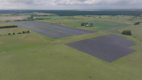 Huge-solar-park-in-rural-meadow-during-cloudy-weather,-generating-no-energy