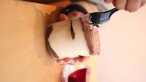 person eating tiramisu dessert