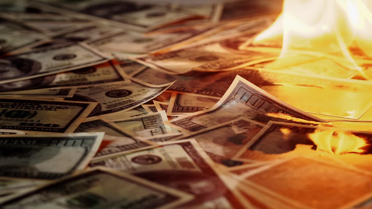 Banconote da cento dollari che bruciano in un mucchio di fiamme
