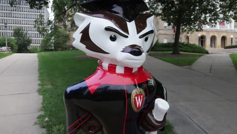 bucky badger mascot statue holding diploma on the campus of the university of wisconsin in madison, wisconsin with gimbal video walking forward