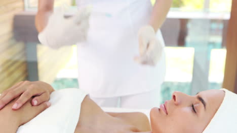 woman receiving botox injection on her lips