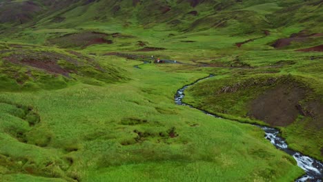 evergreen mountains with winding hot spring river at reykjadalur valley in southern iceland