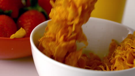 Cereal-pouring-into-a-bowl-at-breakfast-table