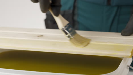 painting wooden plank with paintbrush