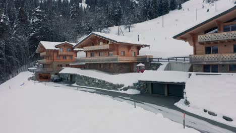 Aerial-of-beautiful-wooden-chalet-in-a-snow-covered-landscape