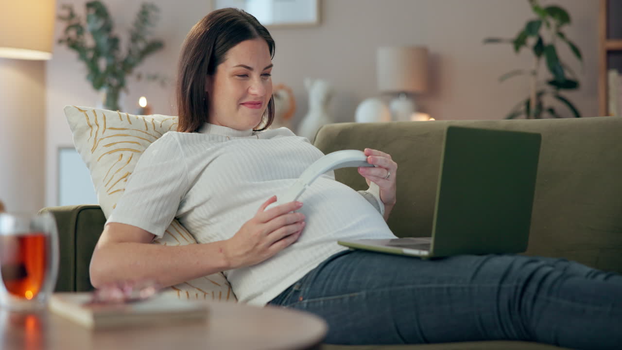 Pregnant woman listening to music with headphones on her belly
