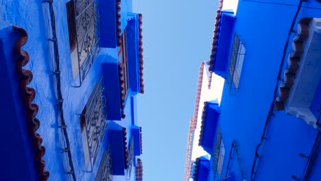 look up of unique blue buildings in chefchaouen, the blue city in morocco, tilt up shot