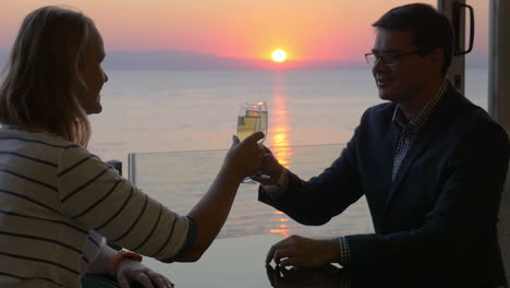 Pareja-Brindando-Con-Vino-Y-Disfrutando-De-La-Puesta-De-Sol-Sobre-El-Mar