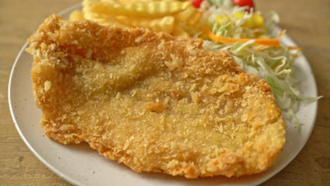 fried fish fillet and potatoes chips with mini salad